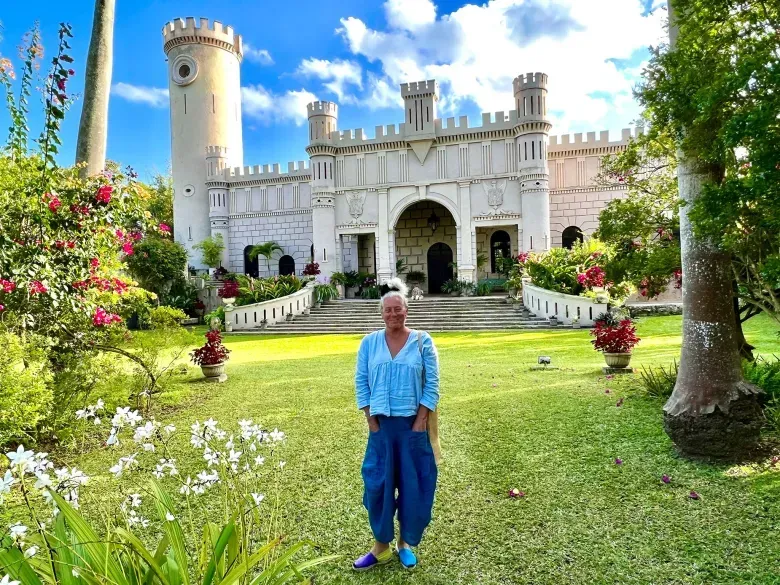 A woman is standing in front of a castle.