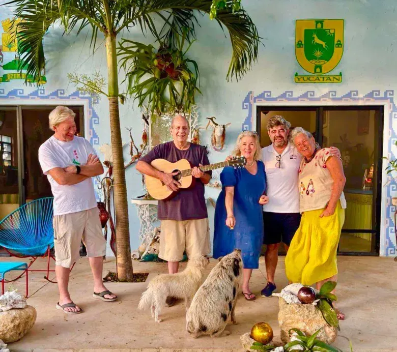 A man is playing a guitar in front of a group of people