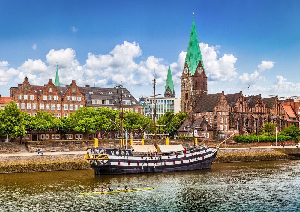 Vor einer Stadt liegt ein Boot im Wasser.