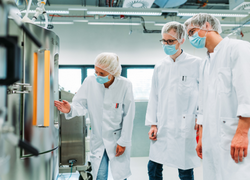 Scientists in front of a bioreactor containing ALiCE lysate