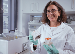 Scientist holding an ALiCE cell-free protein expression kit