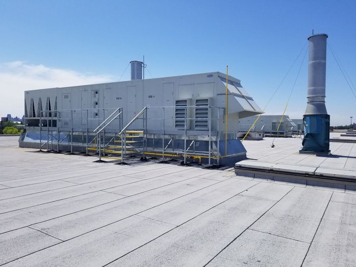 A large white box is sitting on top of a snow covered roof.