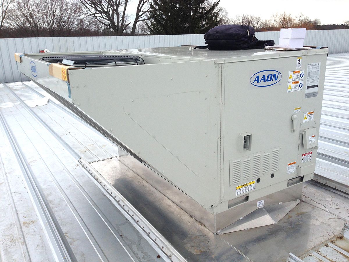 A large white box is sitting on top of a metal roof.