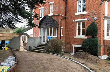 A large brick house with a driveway being built in front of it.