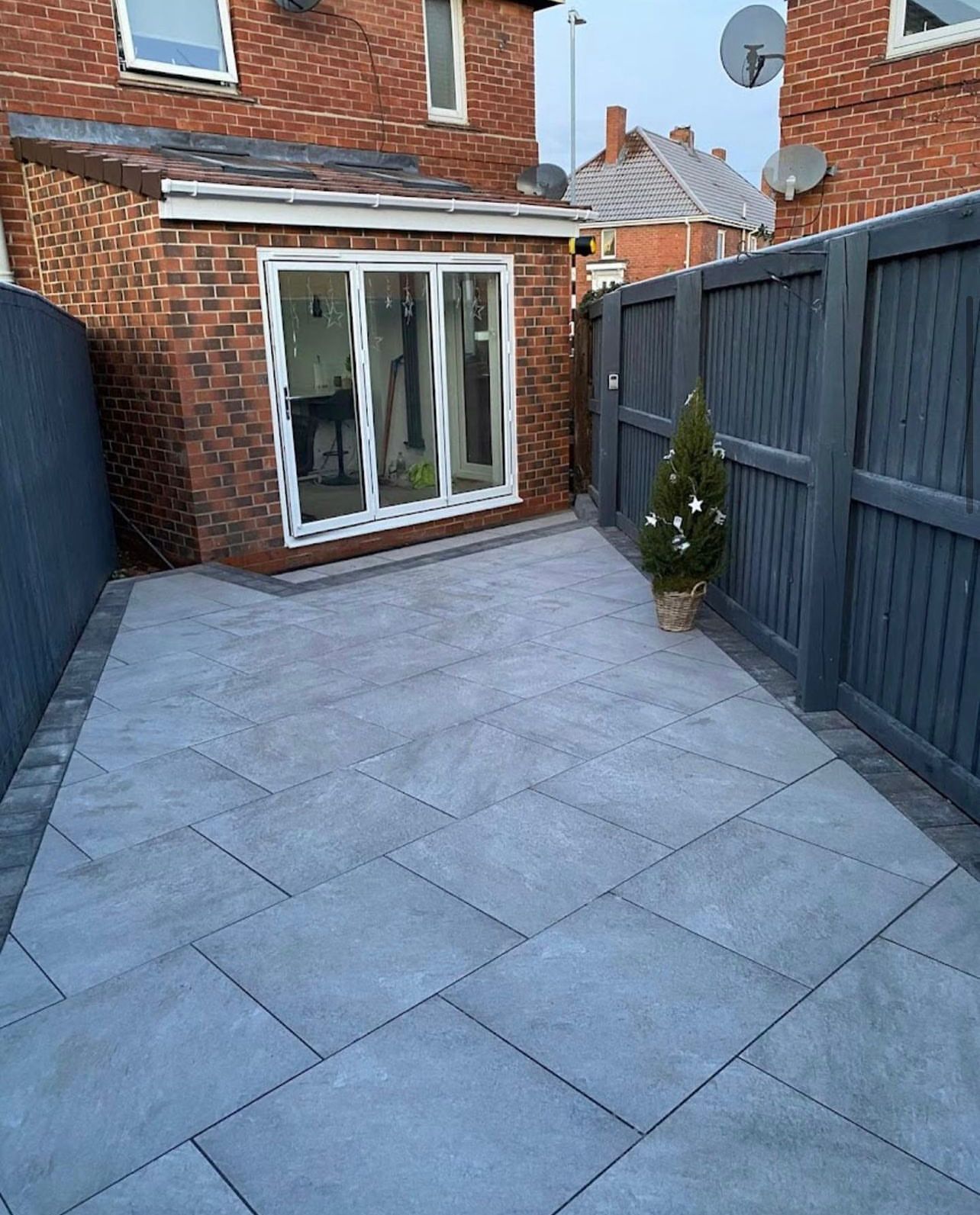 A brick house with a fence and a patio in front of it