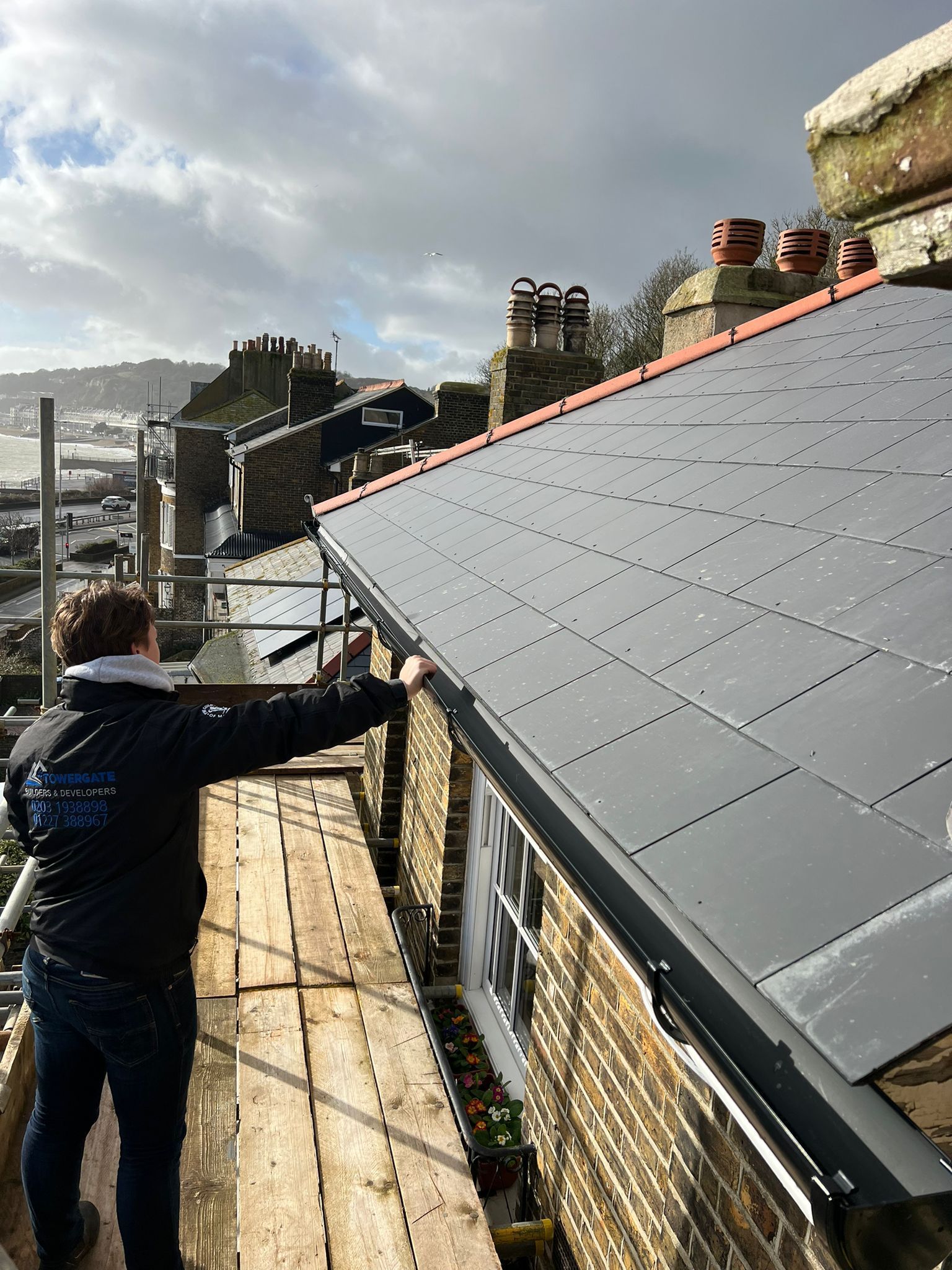 A man is working on the roof of a building.