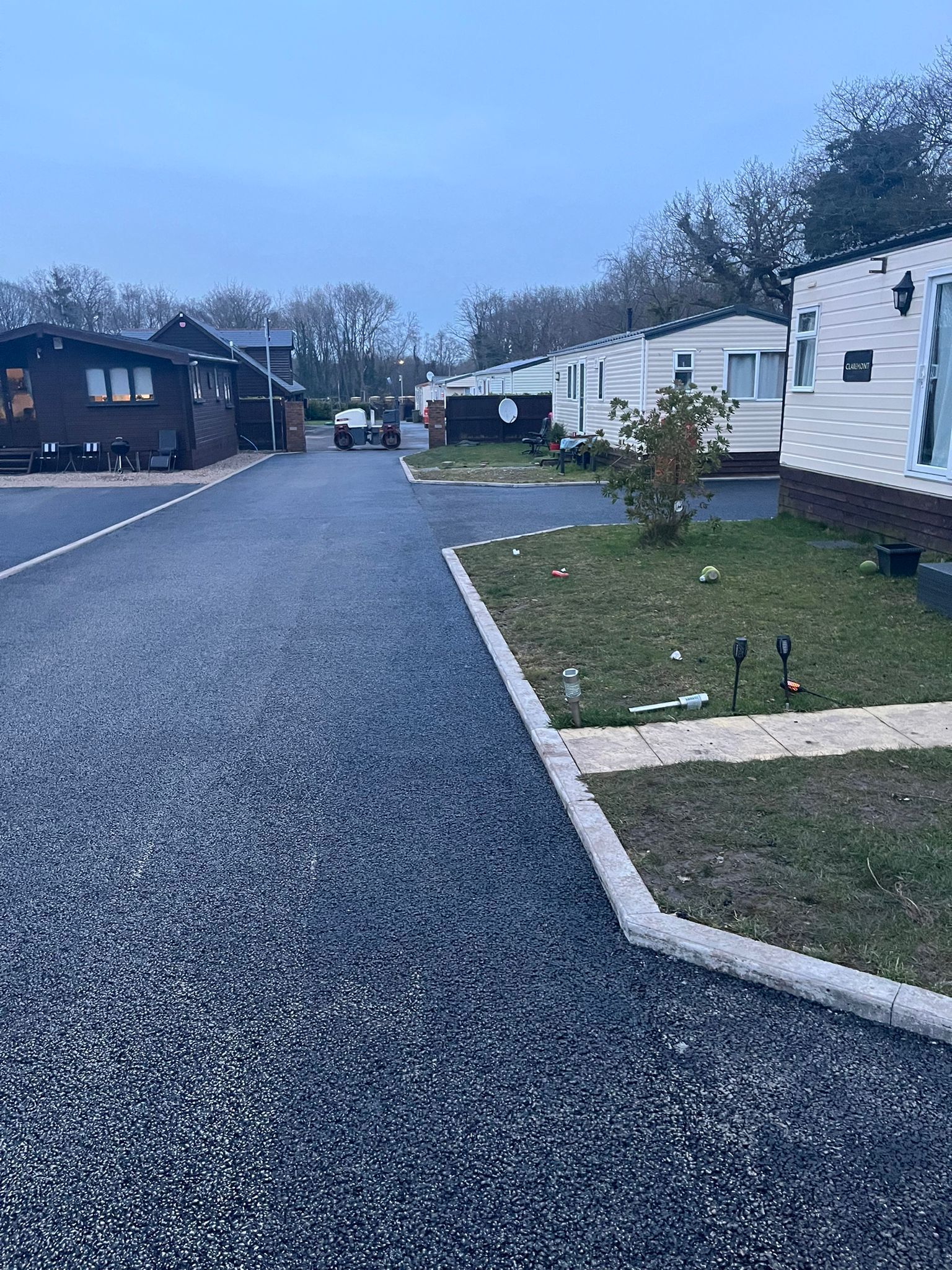 A row of mobile homes are parked on the side of a road.