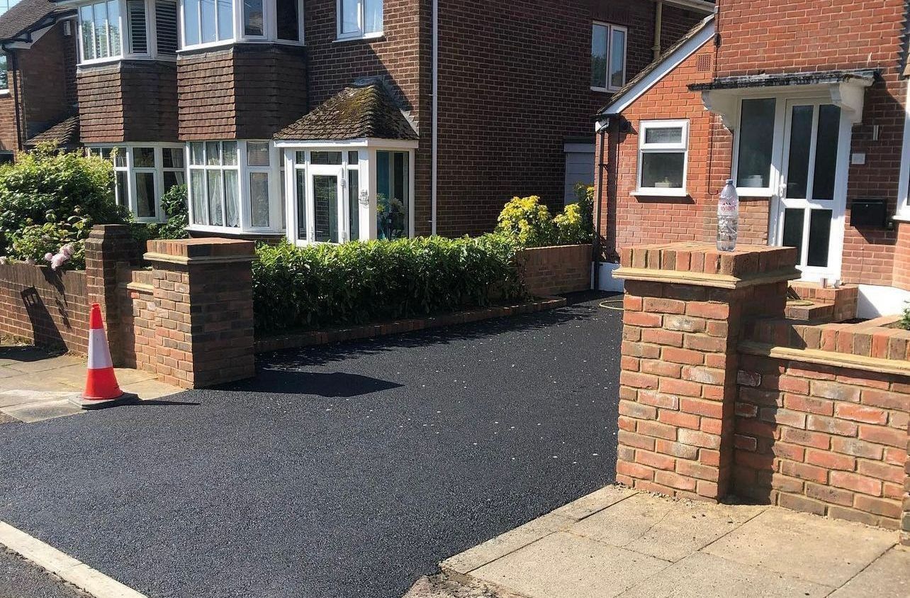 A brick driveway leading to a garage with a white garage door.