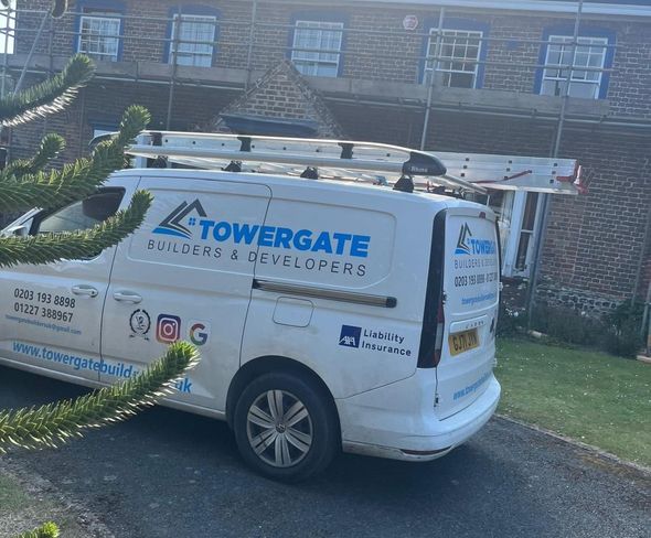 A towergate van is parked in front of a brick building.