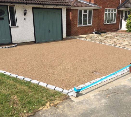 A driveway in front of a house with a blue garage door