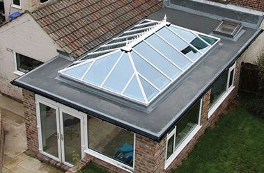 An aerial view of a house with a skylight on the roof.