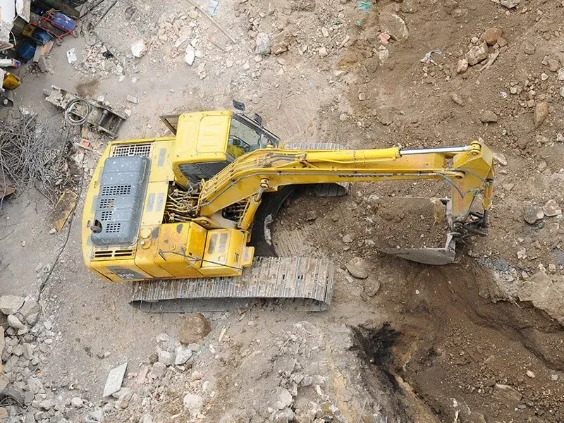 Una excavadora amarilla está cavando un hoyo en el suelo.