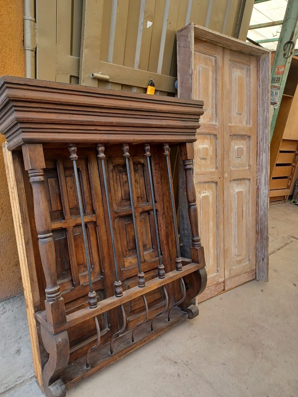 Un estante de madera está al lado de una puerta de madera.