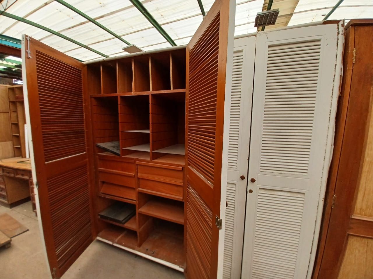 Un armario con las puertas abiertas y muchos estantes y cajones.