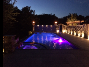 A large swimming pool is lit up at night