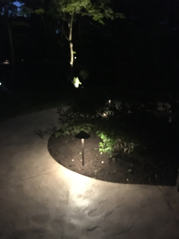 A concrete walkway with a light in the middle of it at night.