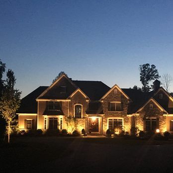 A large brick house is lit up at night.