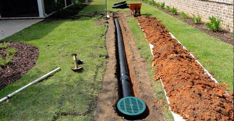 A drain pipe is being installed in a yard.