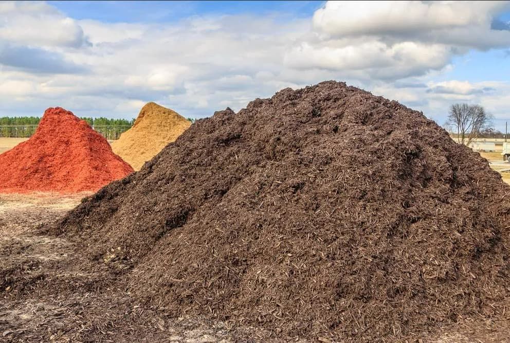 Mound of black mulch or wood chips use — Ryans Turf in Ulladulla, NSW