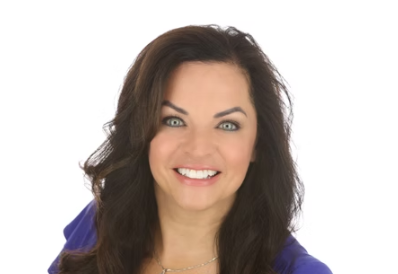 Woman with dark hair smiles, wearing a blue top, against a white background.