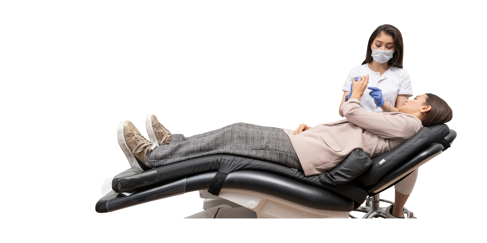 a woman is laying in a dental chair talking to a dentist .