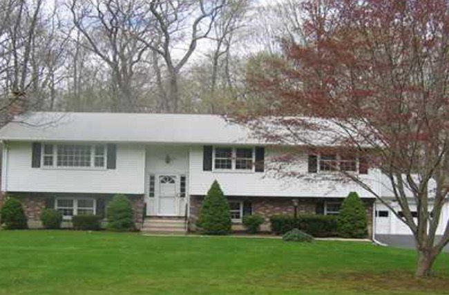 A large white house with a lush green lawn in front of it