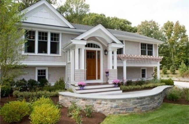 A large house with a stone wall in front of it