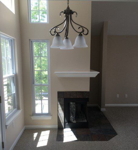 A living room with a fireplace and a chandelier hanging from the ceiling