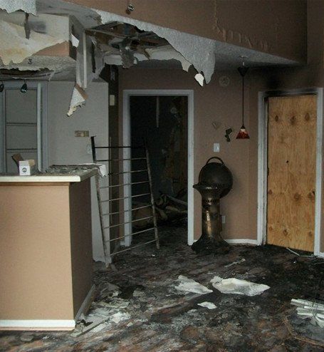 A room with a broken ceiling and a wooden door