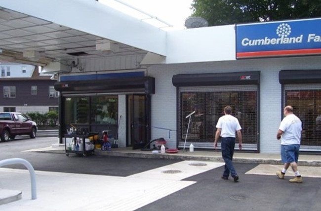Two men walking in front of a cumberland farms store