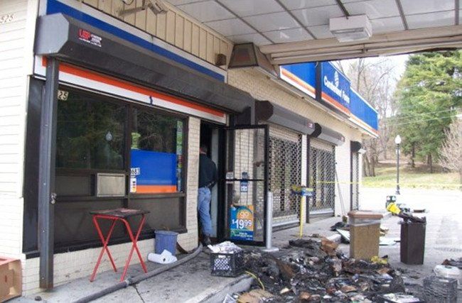 A man is standing in front of a store that has a sign that says ' ucsd ' on it