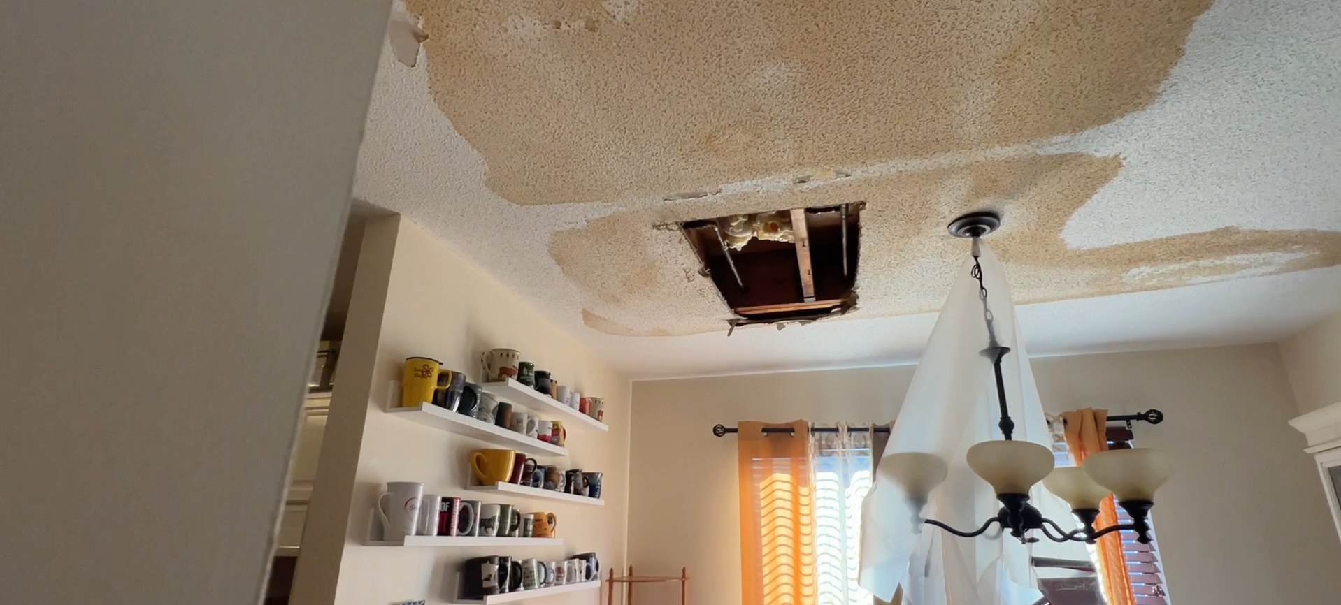 There is a hole in the ceiling of a living room.