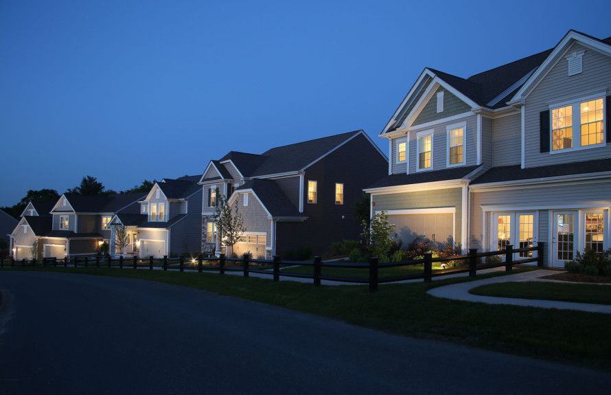 A row of houses are lit up at night in a residential area