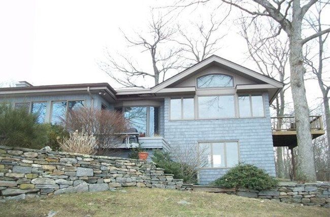 A large house with a stone wall in front of it