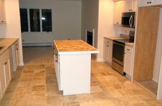 An empty kitchen with a large island in the middle