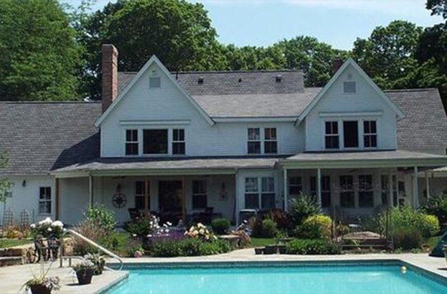 A large white house with a swimming pool in front of it