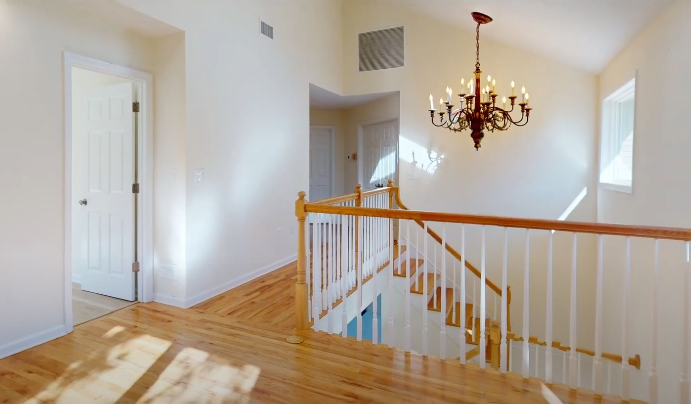 A man with a beard and hat is sitting in front of a purple background.