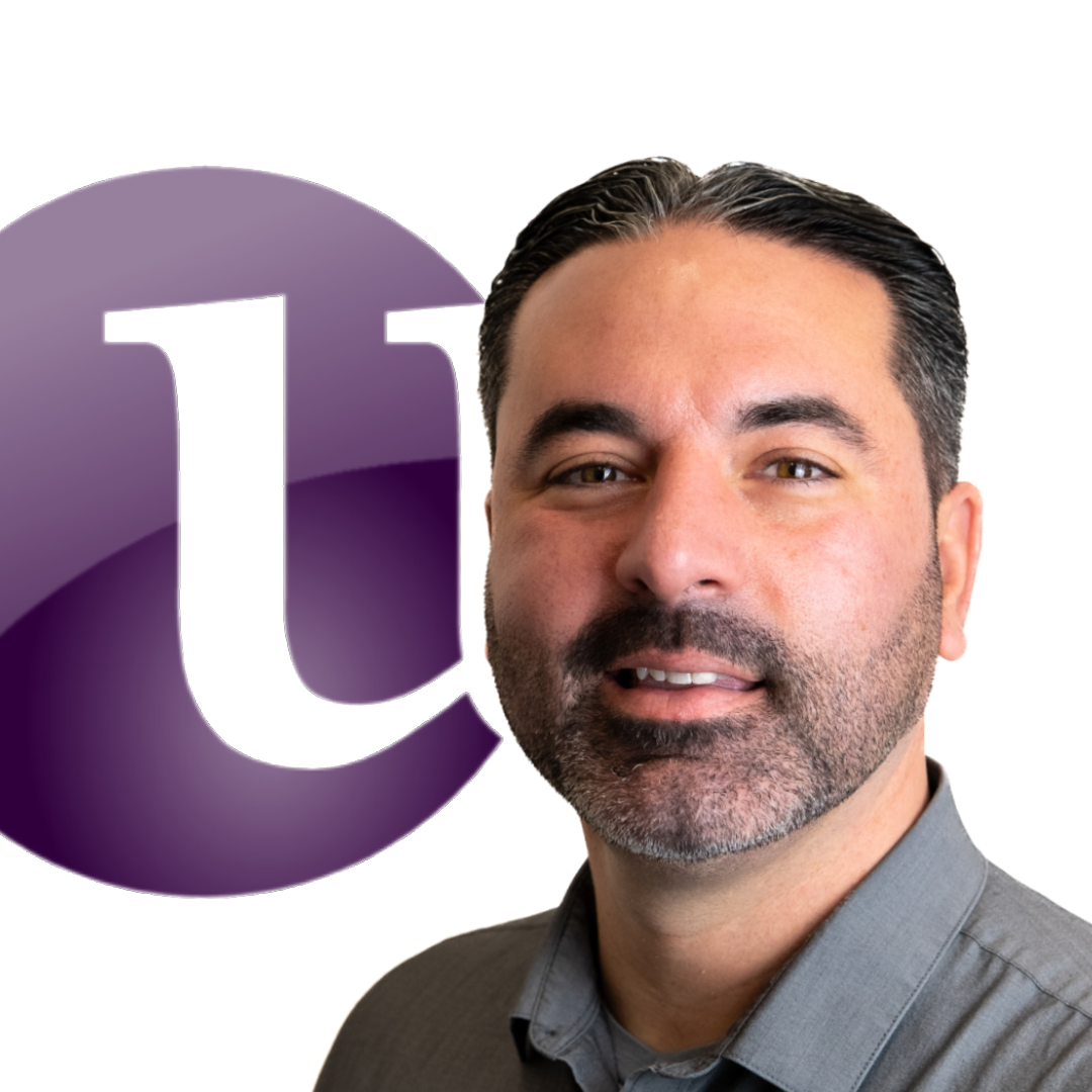 A man with a beard is smiling in front of a purple letter u