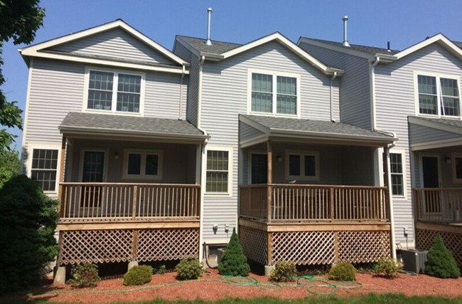 A row of houses with porches and a blue sky in the background