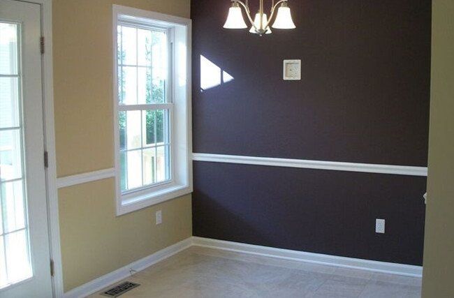 An empty room with brown walls and a window