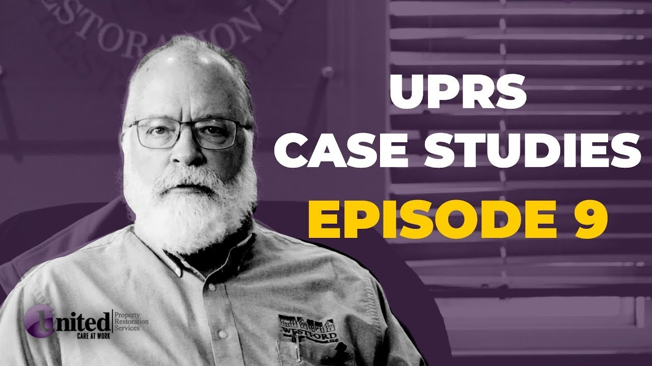 A man with a beard and glasses is standing in front of a sign that says uprs case studies episode 9