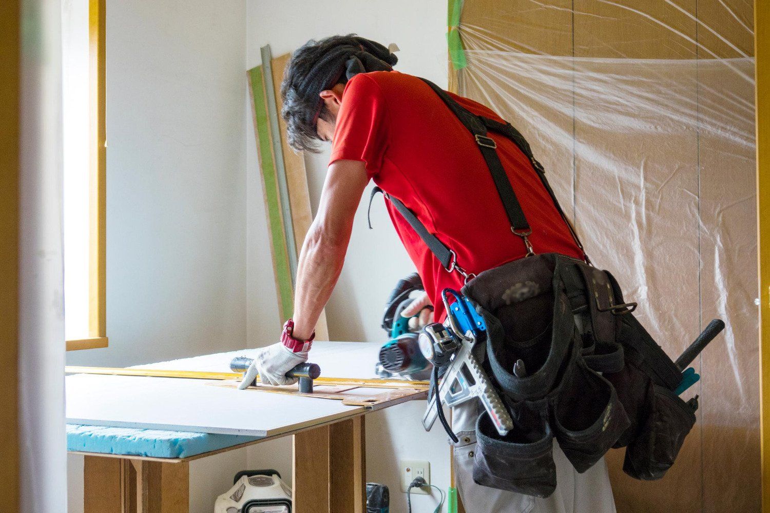 A man is cutting a piece of wood with a circular saw.