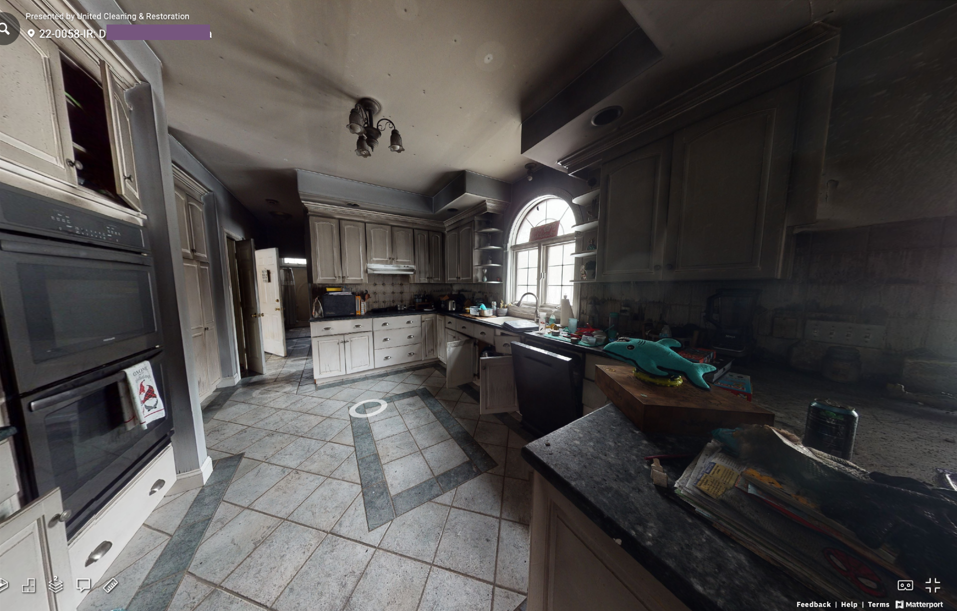 A kitchen with a lot of cabinets and appliances and a tiled floor.