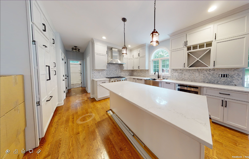 A kitchen with white cabinets and a large island in the middle.