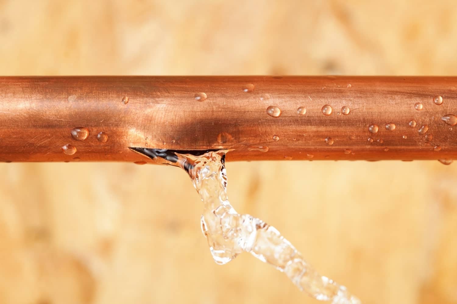 A copper pipe with water leaking out of it.