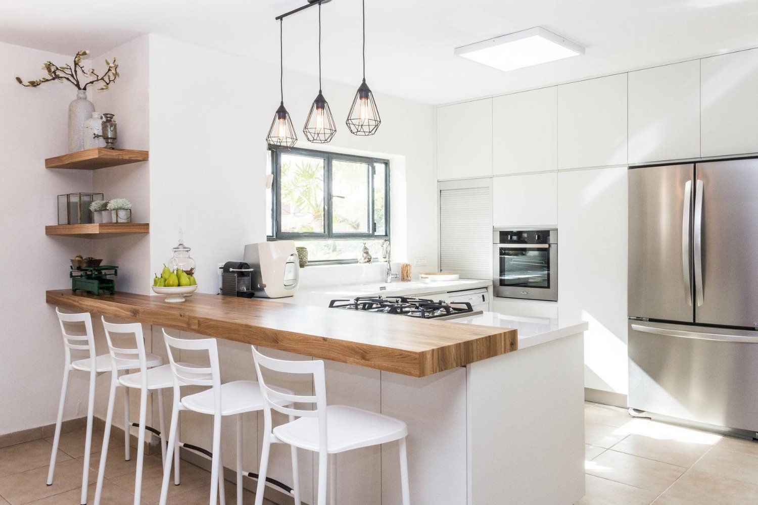 A kitchen with white cabinets and stainless steel appliances and a wooden counter top.