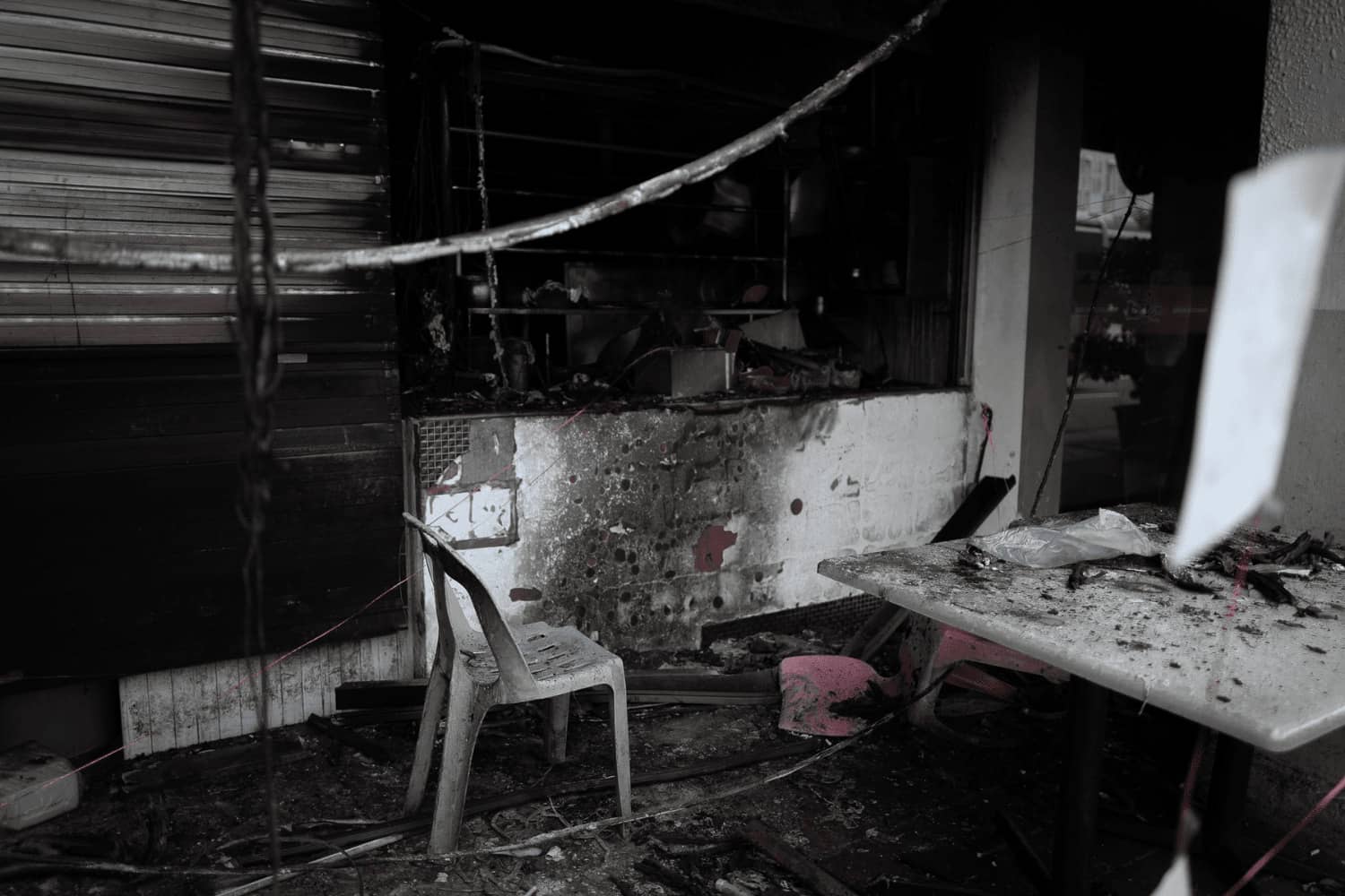 A black and white photo of a room with a table and chairs.