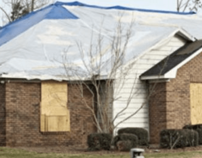 A house with a blue tarp on top of it