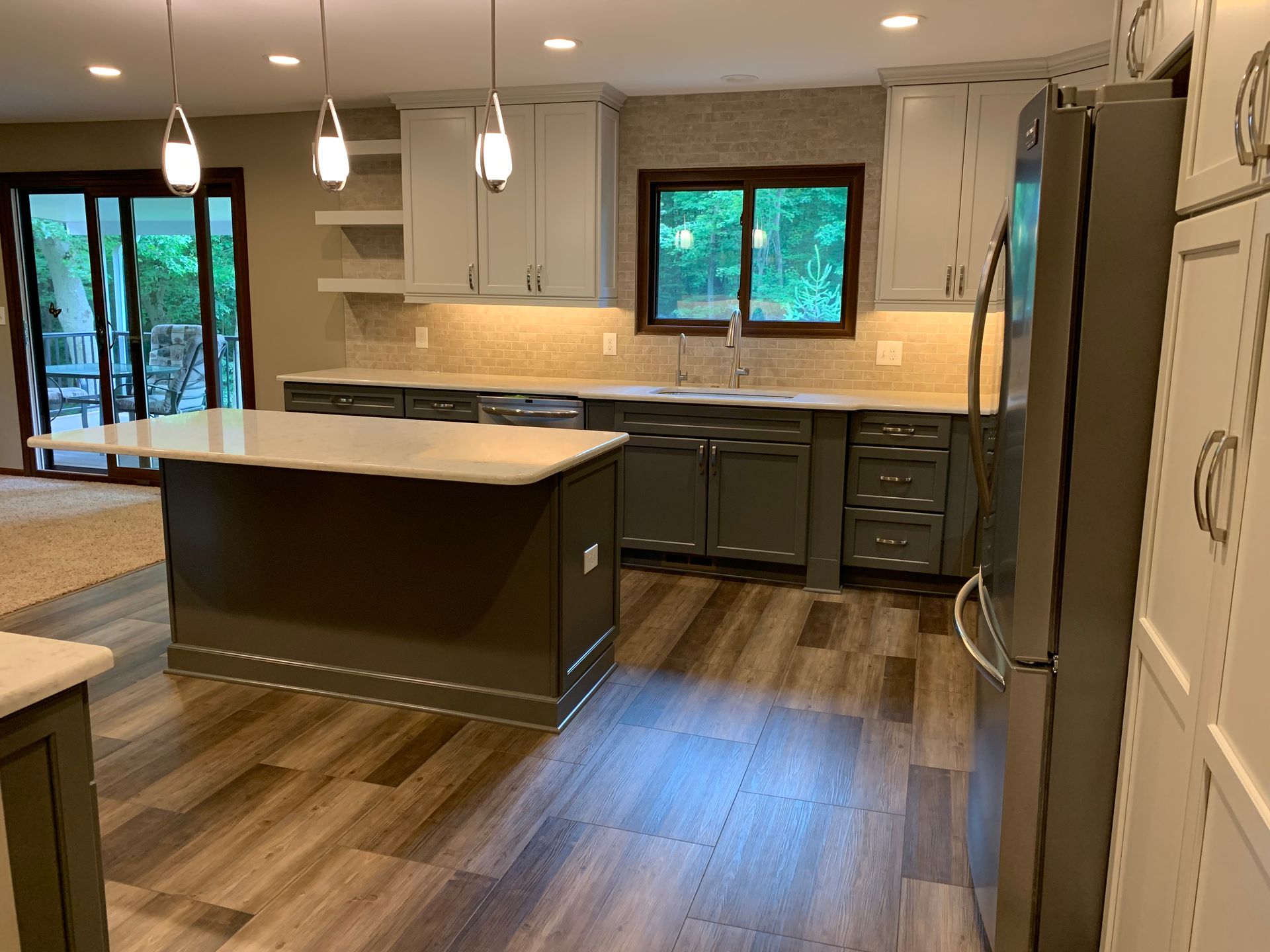 A Kitchen With Gray Cabinets , White Counter Tops , and a Refrigerator  — Clarkston, Michigan — Hidden Lake Cabinet & Trim LLC