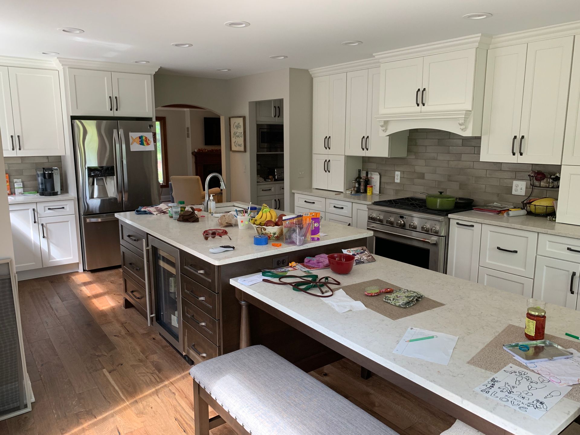 A kitchen with white cabinets and stainless steel appliances and a large island.